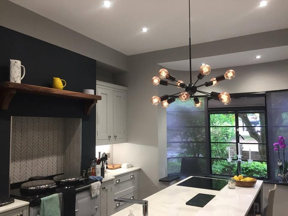Open-plan kitchen with a sputnik pendant chandelier and recessed LED downlights