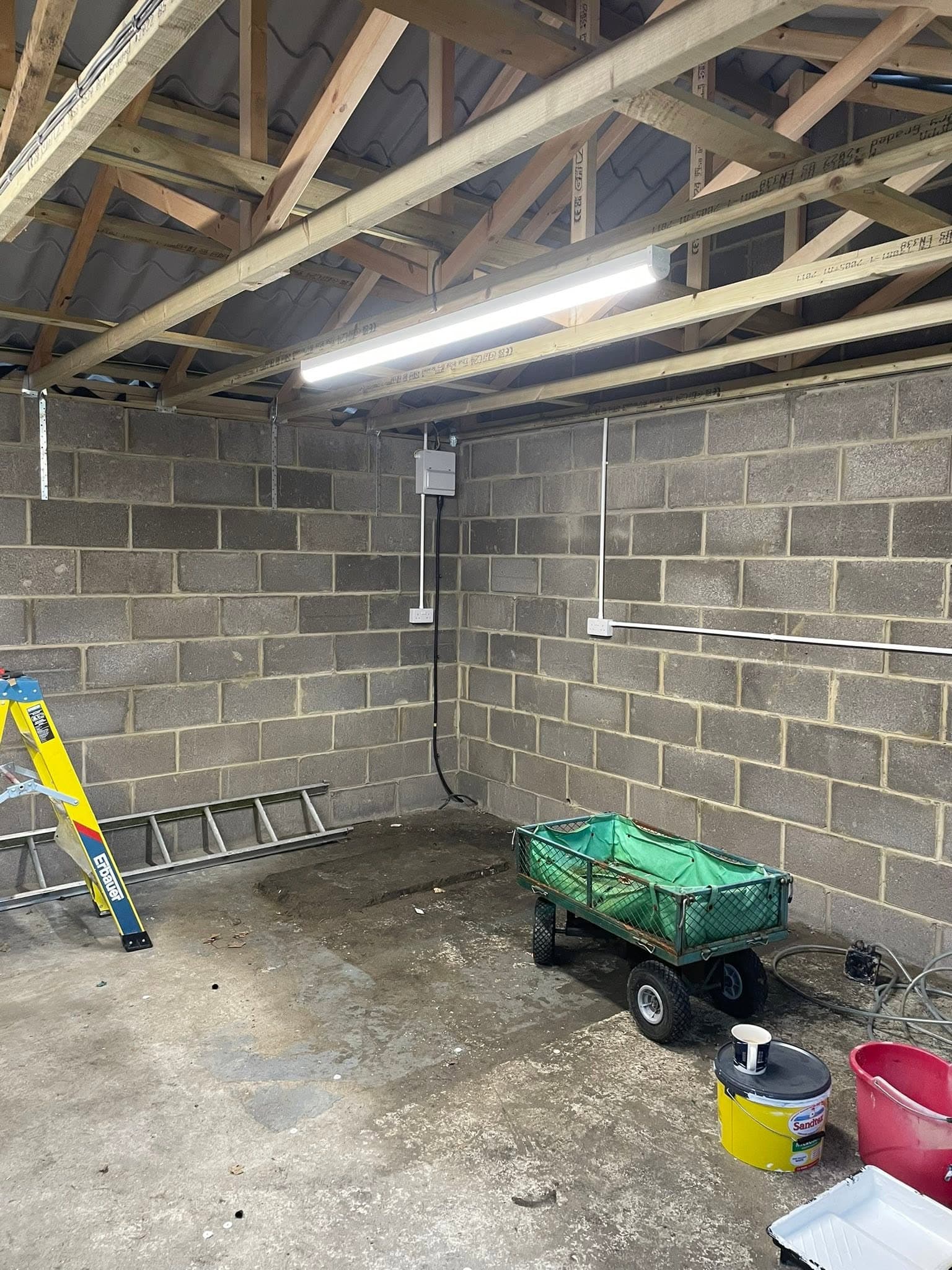 Outbuilding first-fix with a batten LED light, consumer unit and surface cabling