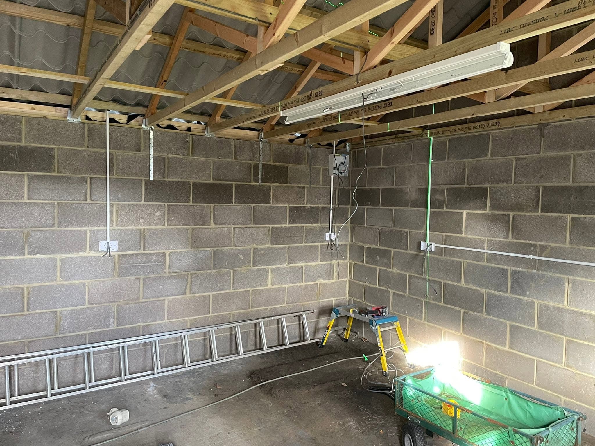 Commercial outbuilding wired with surface-run trunking, twin batten lights and consumer unit